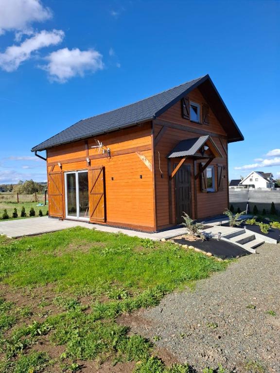 a large wooden cabin with a large door at Chatka Karpatka in Kostrzyca