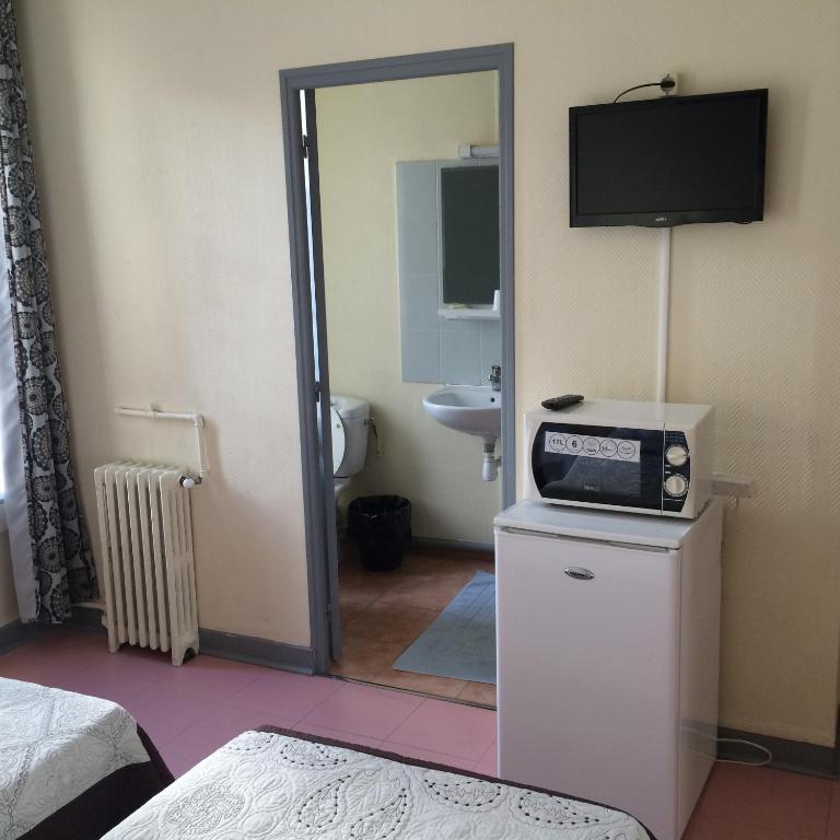 a bathroom with a television on top of a refrigerator at Au Royal Mad in Paris