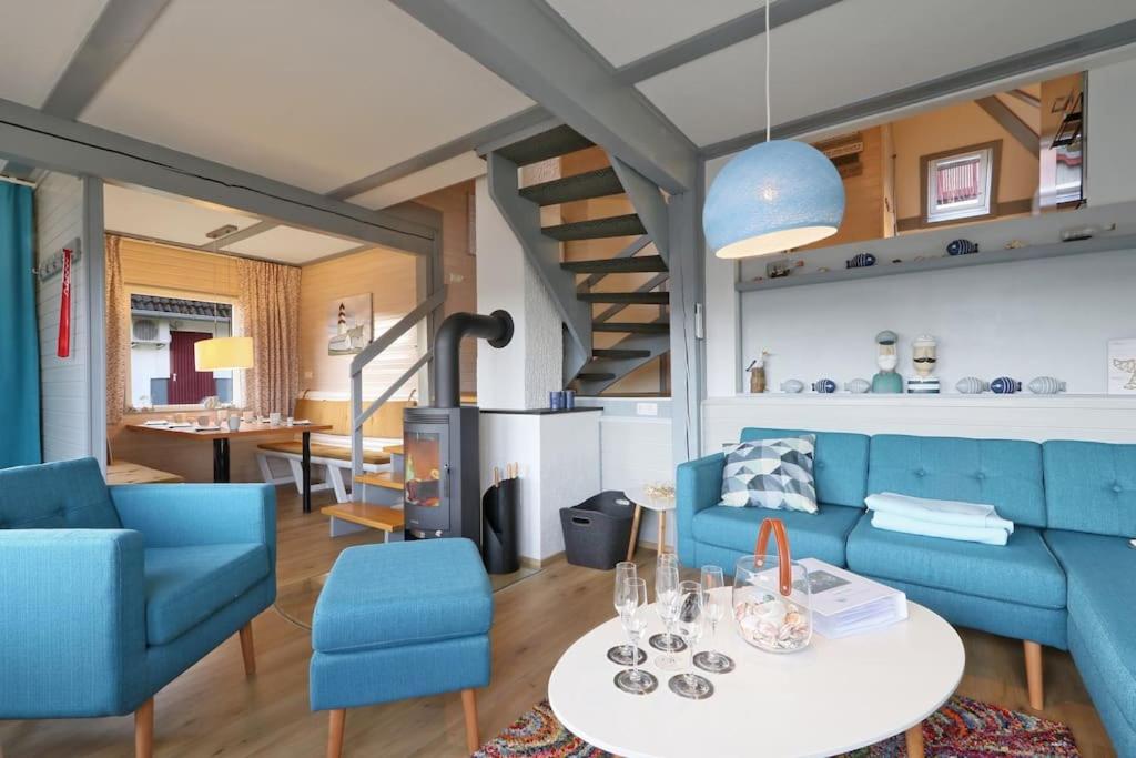 un salon avec un canapé bleu et une table dans l'établissement Haus Sonnenschein, Seepark Kirchheim, à Kirchheim