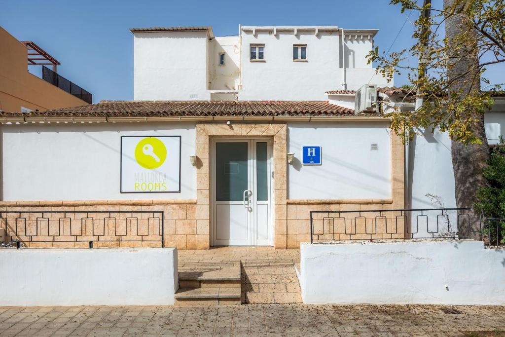 坎帕斯蒂利亚Mallorca Rooms Can Pastilla的门上标有标志的白色建筑