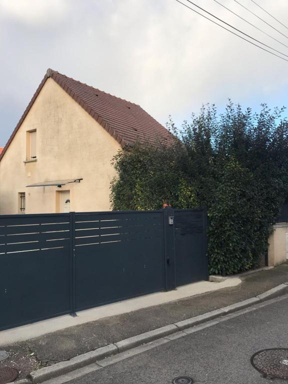 a blue fence in front of a house at La Petite Maison in Montbard