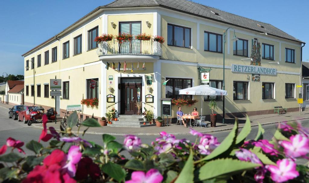 um edifício na esquina de uma rua com flores em Retzerlandhof Familie Graf em Zellerndorf