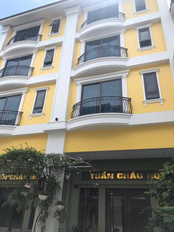 a tall yellow building with a sign for a hair salon at Tuần Châu HQT in Ha Long