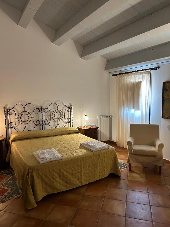 sypialnia z łóżkiem i krzesłem w obiekcie Torre Archirafi Resort w mieście Riposto