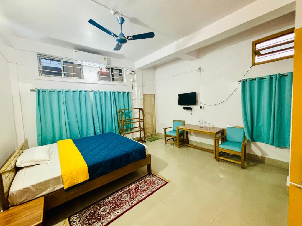 SibsāgarParag Abode - A Luxury Homestay的一间卧室，配有一张床、一张桌子和几把椅子
