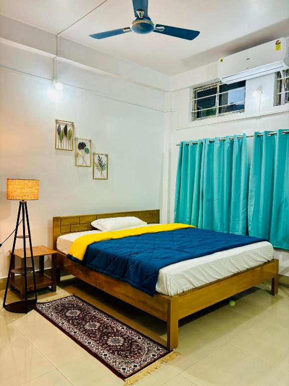 SibsāgarParag Abode - A Luxury Homestay的带床和吊扇的卧室
