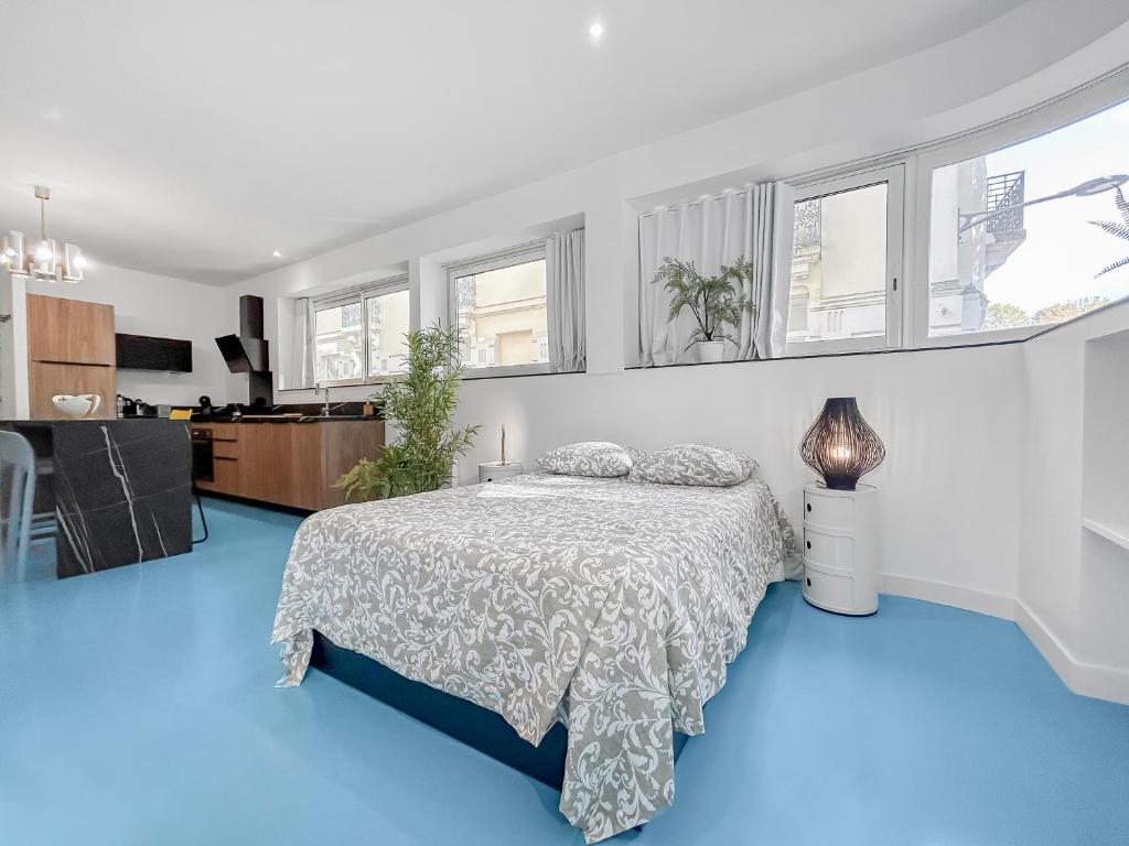 a bedroom with a bed on a blue floor at Appartement lumineux proche du Parc des Sources in Vichy