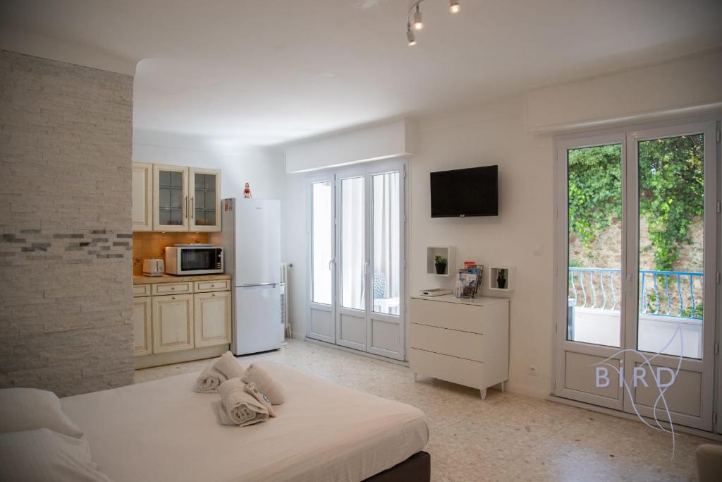 - une cuisine blanche avec un lit et un réfrigérateur dans l'établissement Spacious studio 4 minutes walk from the Beaches, à Cannes