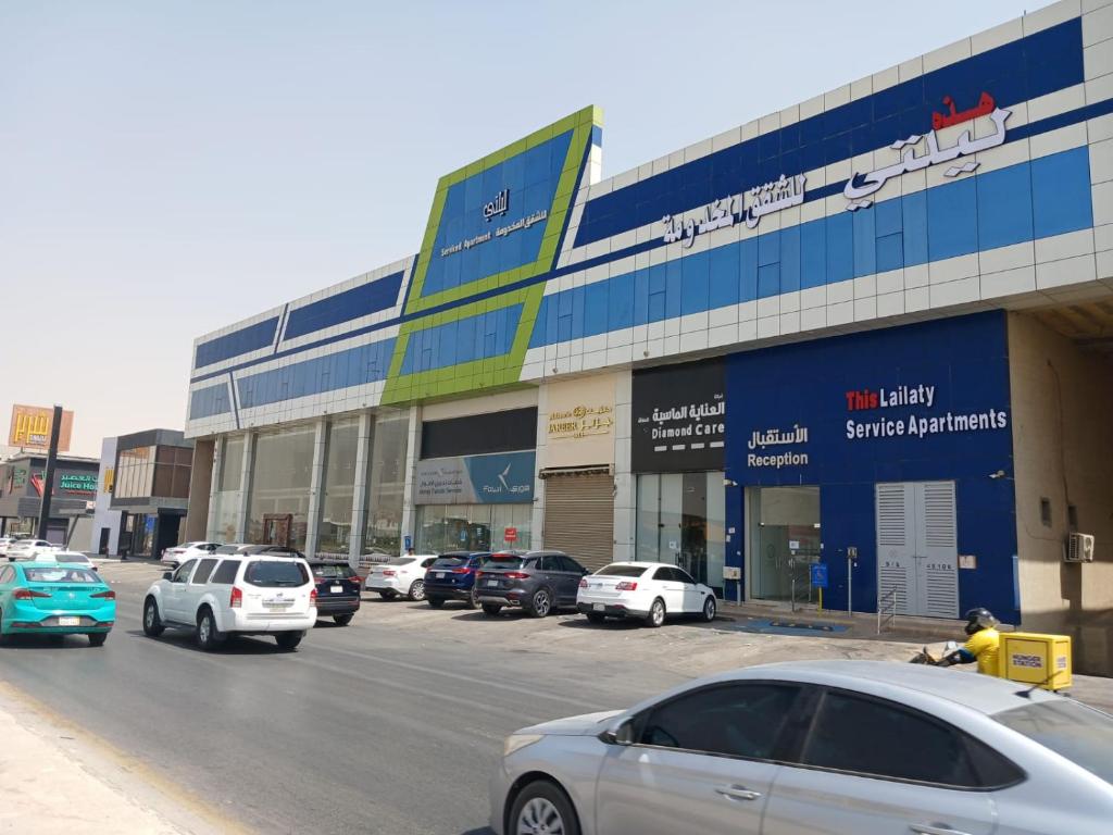 a parking lot with cars parked in front of a building at هذه ليلتي- اليرموك- طريق الدمام This Lailaty Al Yarmouk-Dammam Road in Riyadh