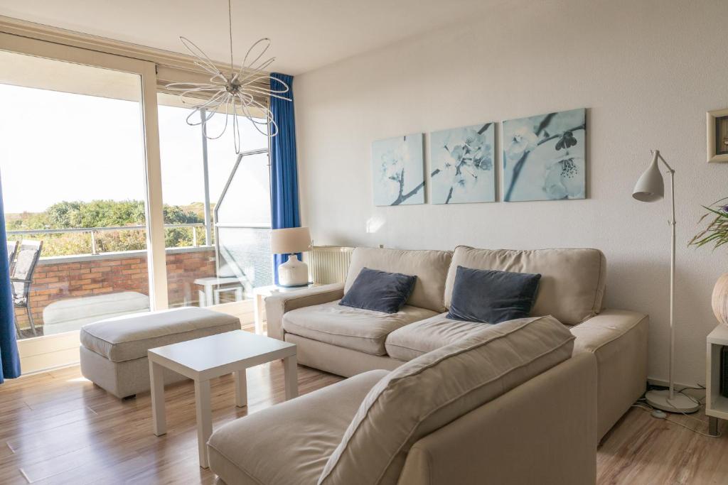 ein Wohnzimmer mit Sofa und Tisch in der Unterkunft Duinerei appartement C102 in Callantsoog