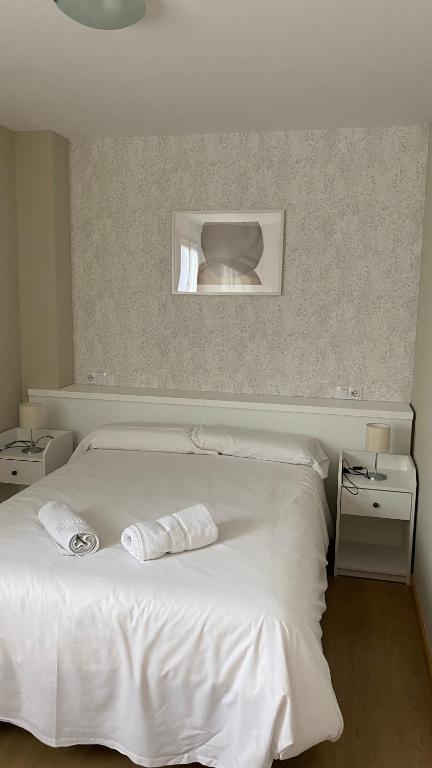 a bedroom with a white bed with two towels on it at Apartamentos Panticosa in Panticosa