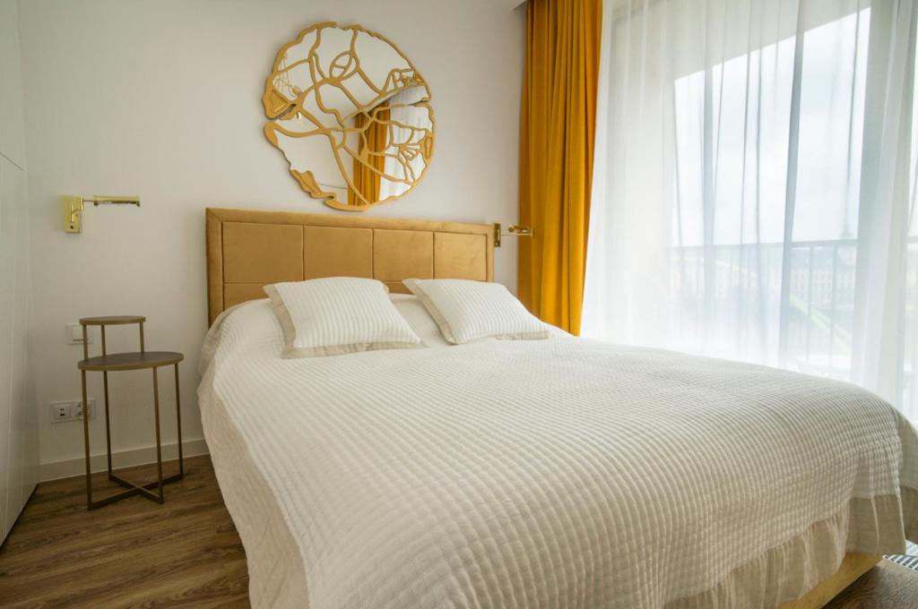 Boulevard Drobnera IV - Apartament nad Odrą - Rynek في فروتسواف: غرفة نوم بها سرير ونافذة كبيرة