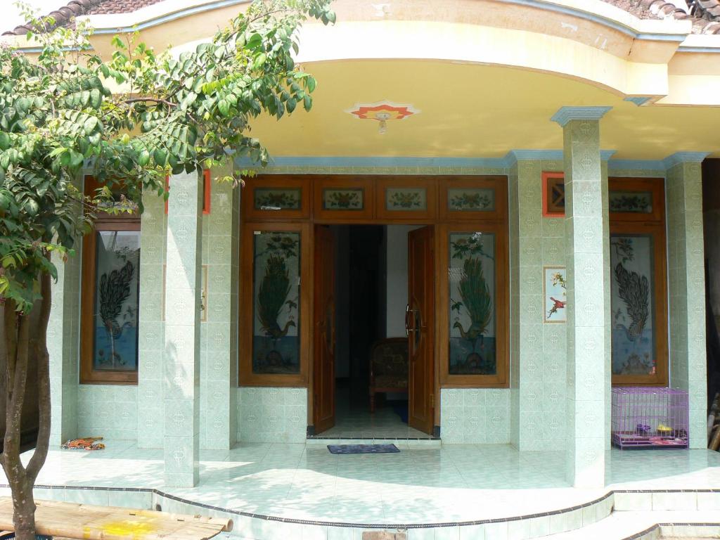 a building with glass doors and paintings on it at Ijen Adventure Inn in Banyuwangi
