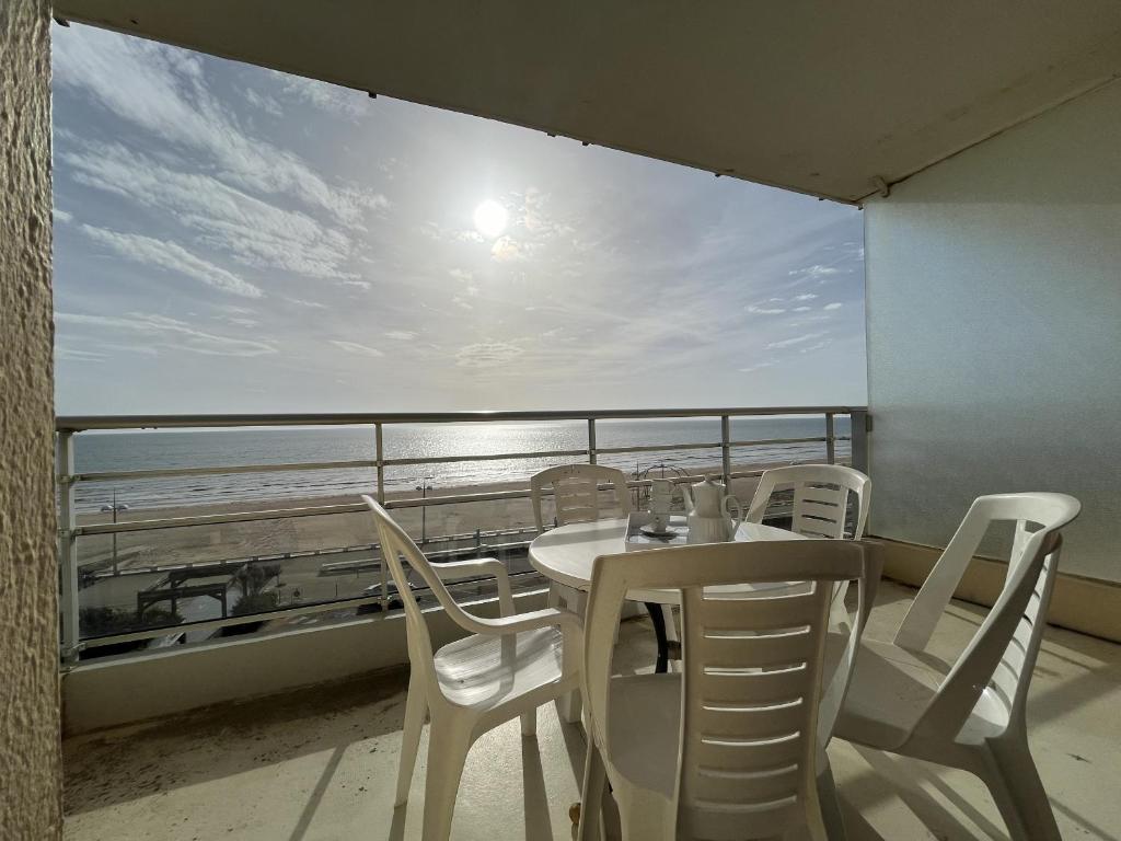 une table et des chaises sur un balcon avec vue sur l'océan dans l'établissement L'Aigue Marine, à Saint-Jean-de-Monts