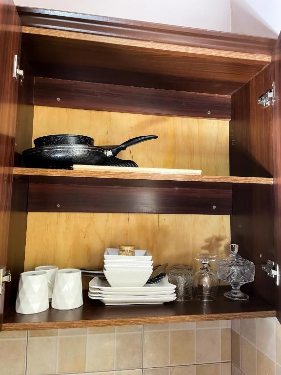 a shelf with plates and utensils in a kitchen at Jay homes Najjera in Buwate