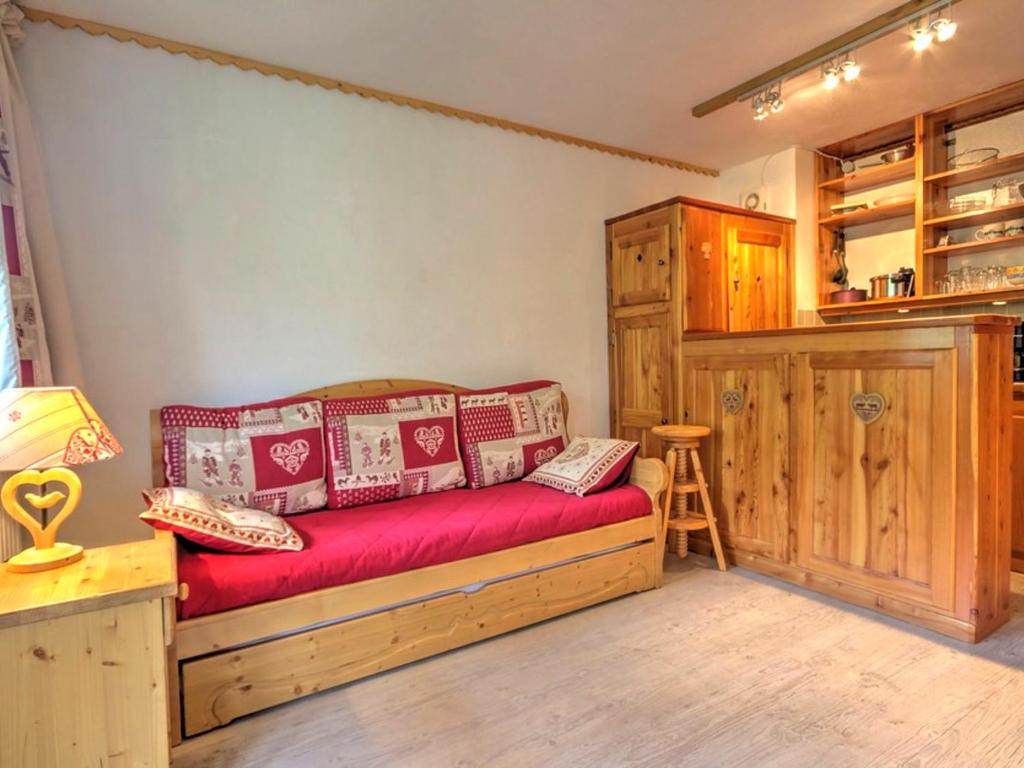 Cette chambre comprend un canapé et un tabouret. dans l'établissement Studio cosy à Plagne Centre avec balcon, proche pistes et centre, skis aux pieds - FR-1-181-2692, à La Plagne Tarentaise