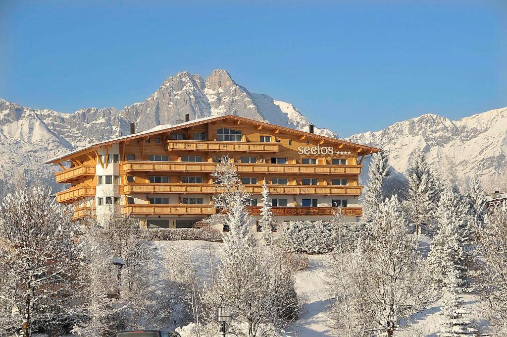 un gran edificio en la nieve frente a una montaña en Hotel Seelos, en Seefeld in Tirol