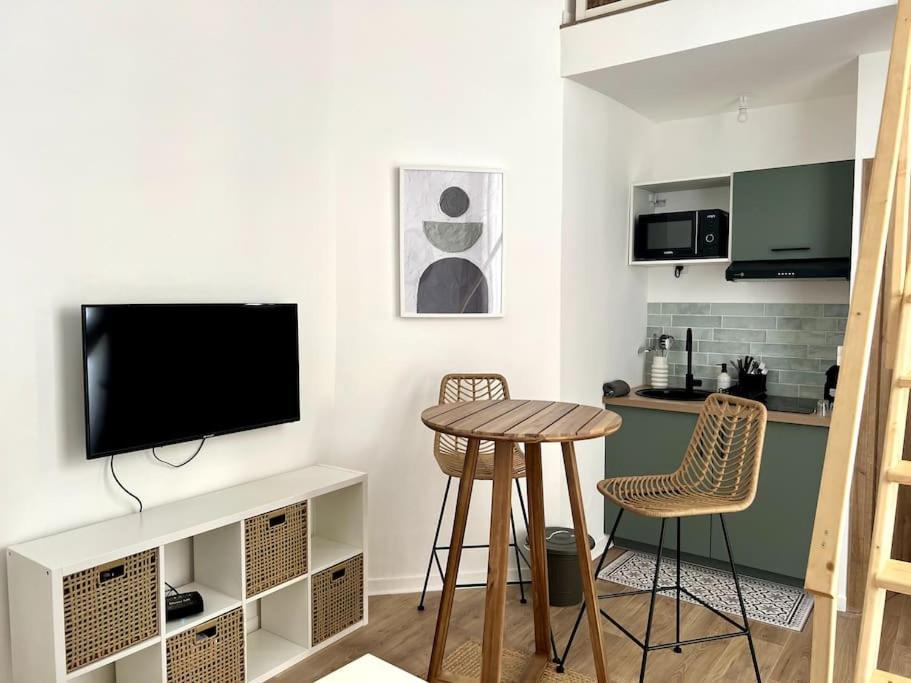 une cuisine avec une table et deux chaises ainsi qu'une télévision dans l'établissement Casa Urbä - Place de la Comédie, Montpellier, à Montpellier