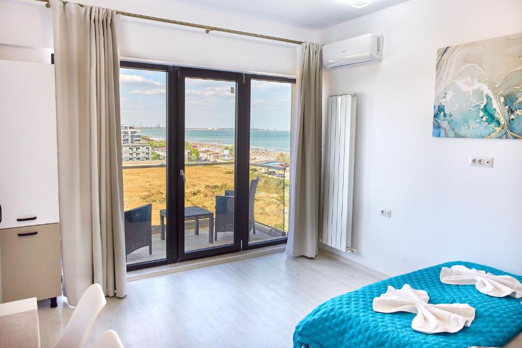 a bedroom with a bed and a view of the ocean at Apartamente Tomis Villa 2 in Năvodari