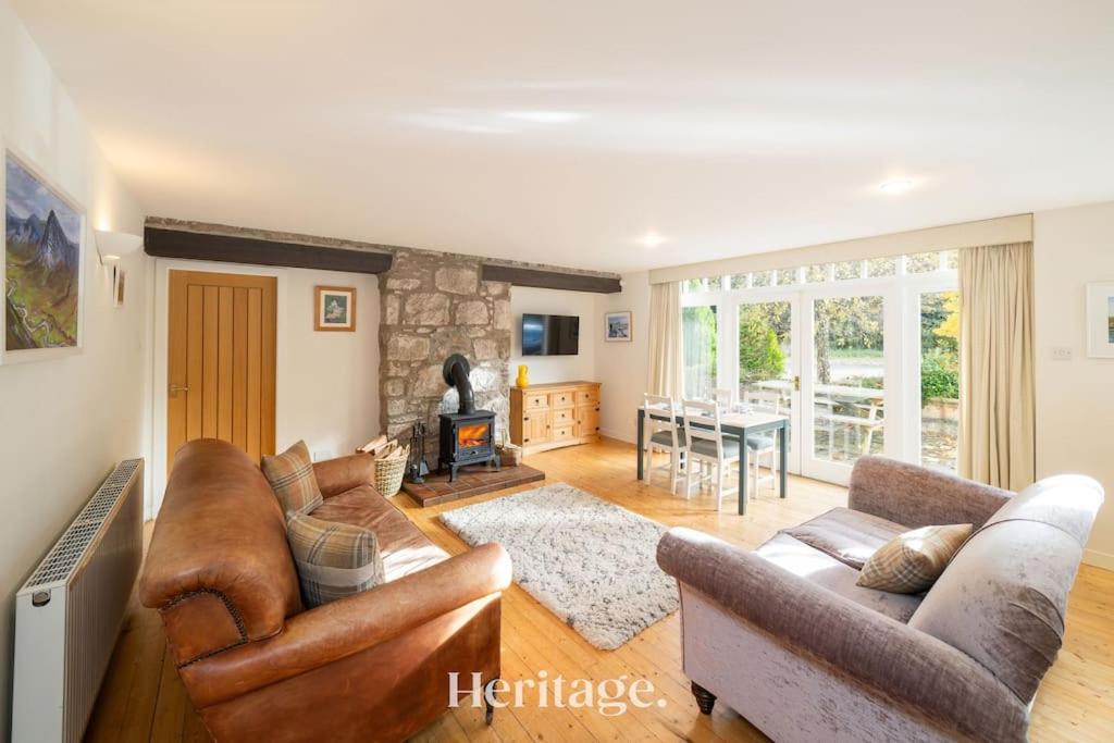 un soggiorno con due divani e un camino di The Stables Cottage, Aboyne, Peaceful Stay in Royal Deeside ad Aboyne