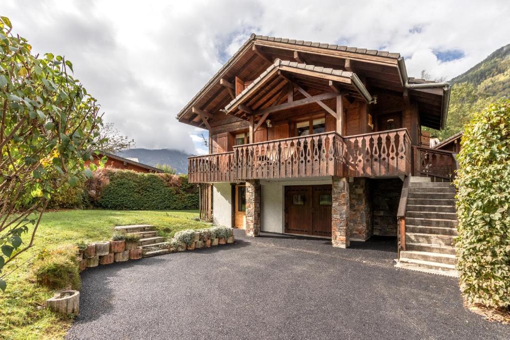 Cette maison en rondins dispose d'un balcon et d'escaliers. dans l'établissement La Bastide - Grand chalet privé - Quartier calme, aux Houches