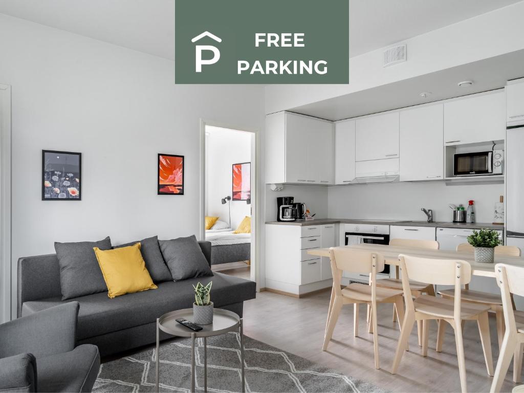 a living room with a couch and a table and a kitchen at Hiisi Homes Turku Ratapiha in Turku