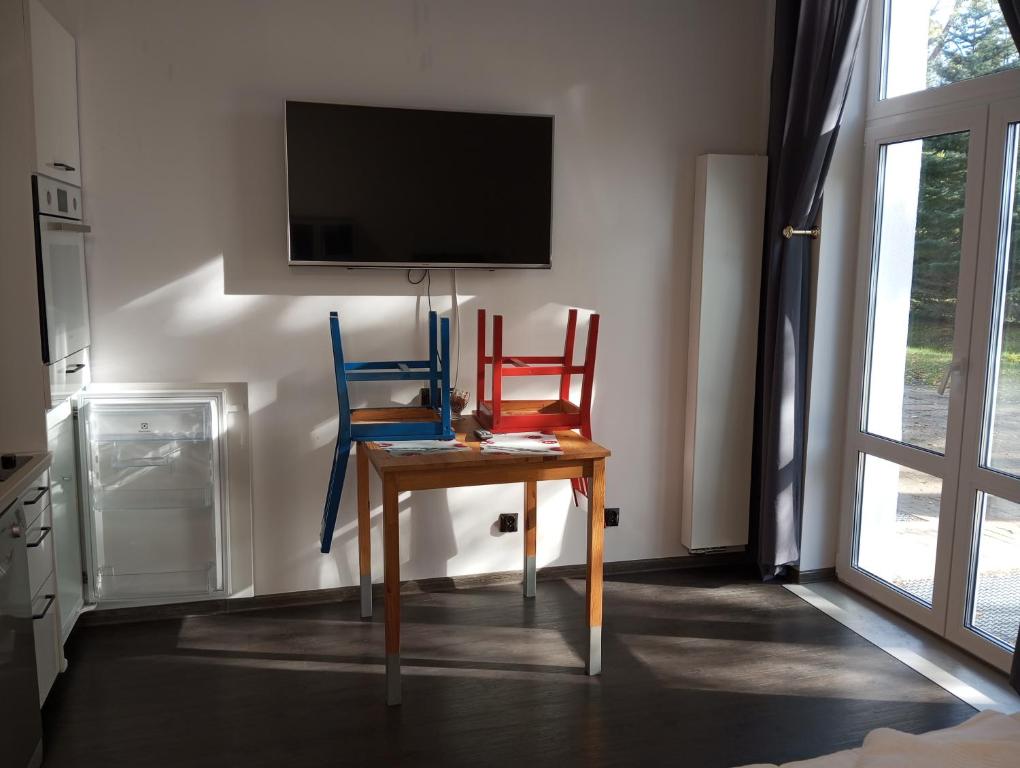 two chairs and a table with a tv on a wall at Mirabella 1 in Kołobrzeg