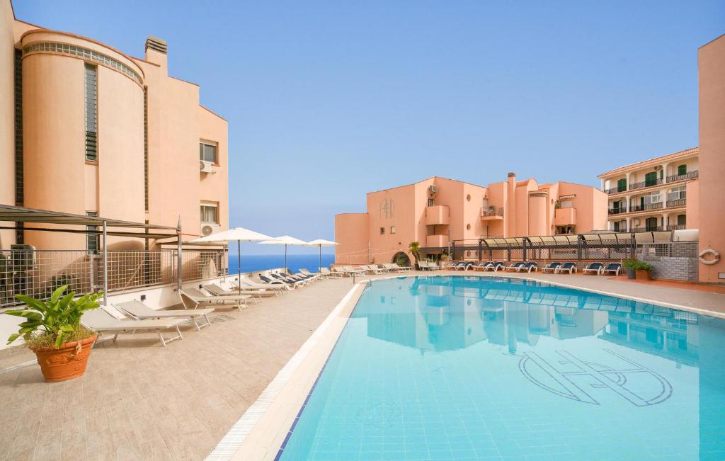 a large swimming pool with chairs and a building at Bilo 4 in Lido di Mondello