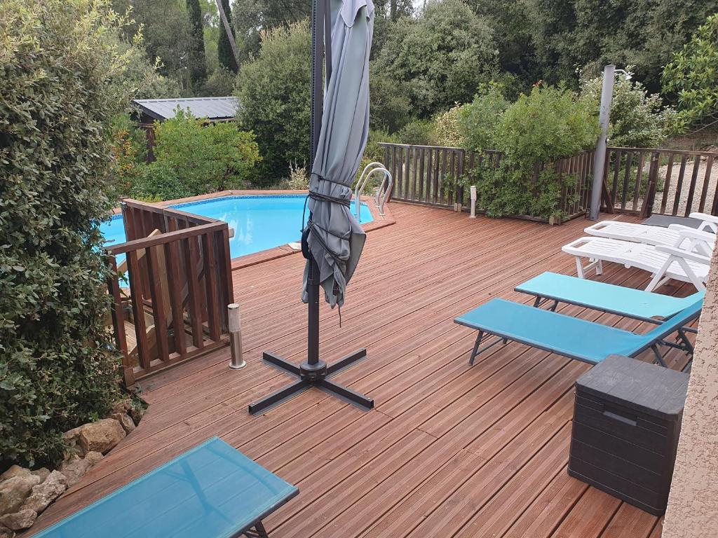 - un parasol sur une terrasse à côté de la piscine dans l'établissement maison vacances 6 à 8 personnes parc du verdon, à Sillans-la-Cascade