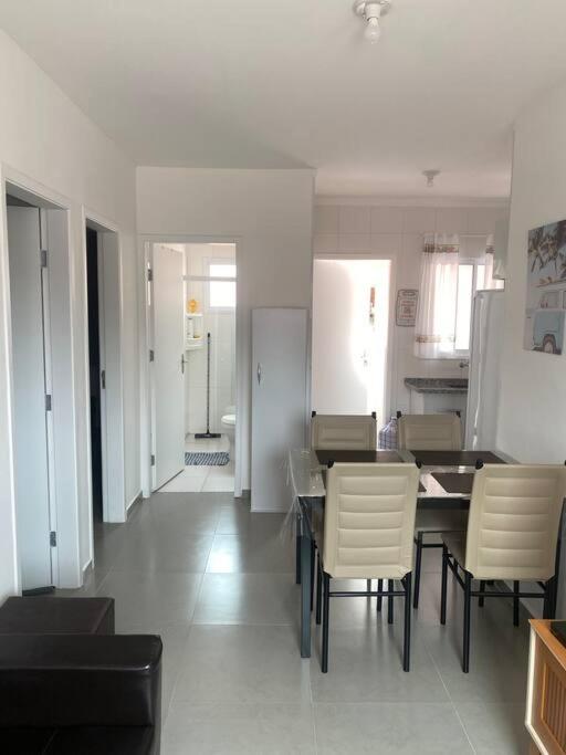 a kitchen and dining room with a table and chairs at Ap praia Bertioga cm garagem in Ilha Monte Pascoal