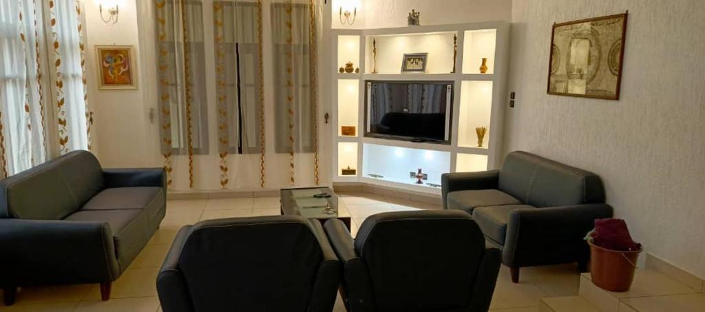 Una sala de estar con dos sofás y un televisor. en Magnifique Villa Meublée, en Cotonou