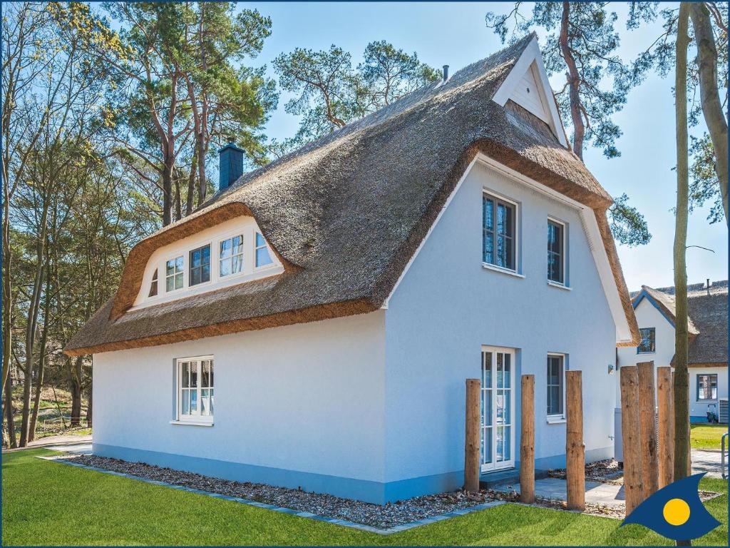 a white house with a thatched roof at Fischerdorf Zirchow Seebär in Zirchow