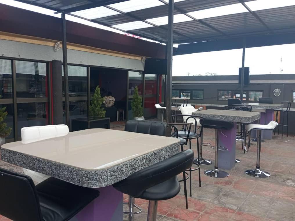 GuluTina Ma Hotel的建筑物内有桌椅的餐厅