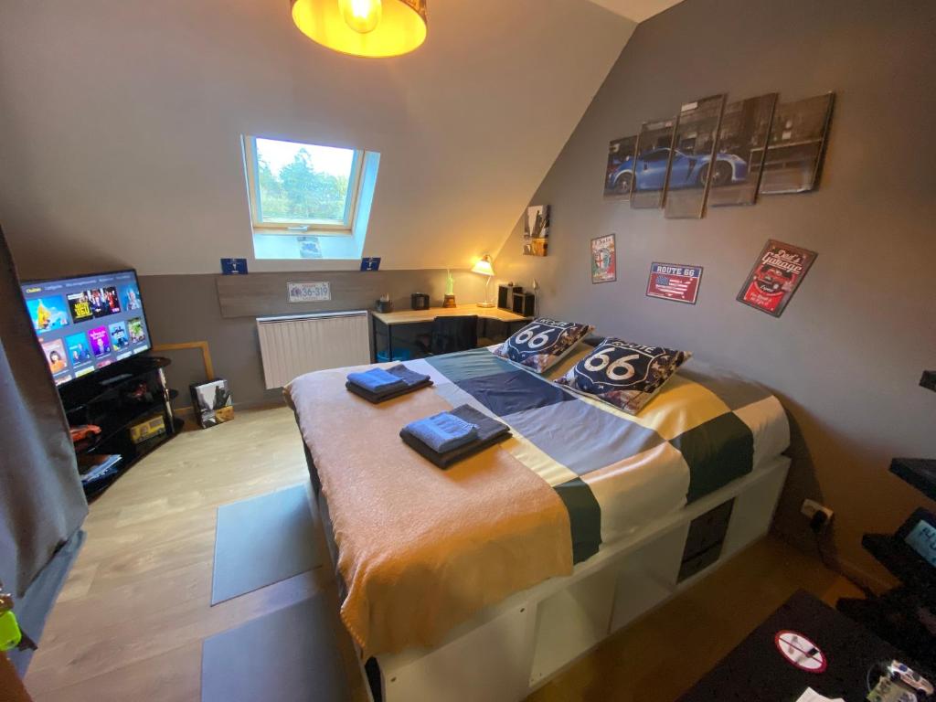 Le VaudouéにあるChambre la Belle Étapeの大きなベッドとテレビのある寝室