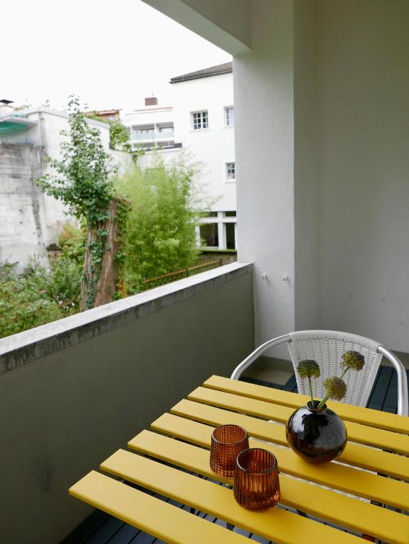 a yellow bench sitting on top of a balcony at Gemütliche Wohnung Nähe Uni in Basel