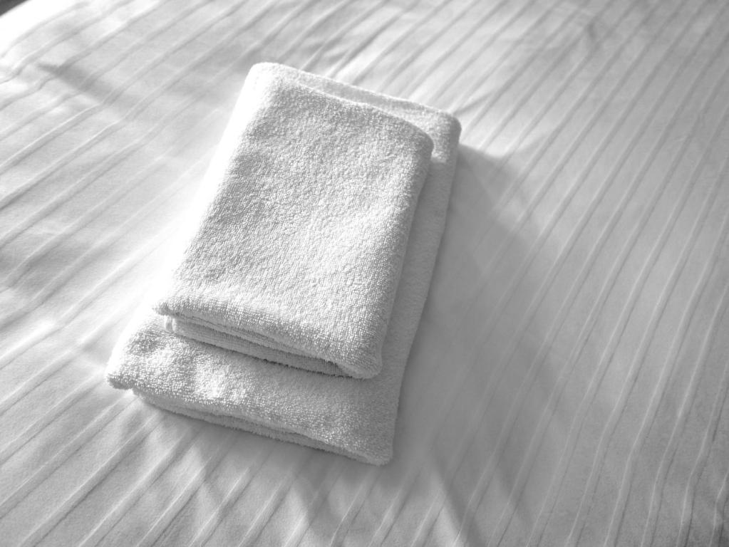 a pile of towels sitting on top of a bed at Gemütliche Wohnung Nähe Uni in Basel