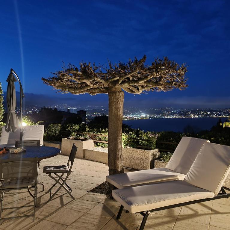 d'une terrasse avec une table, des chaises et un arbre. dans l'établissement Villa Mansart, à Théoule-sur-Mer