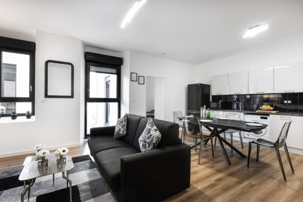 un salon avec un canapé noir et une table dans l'établissement Suite Carla - Superbe appartement à Cannes, à Cannes