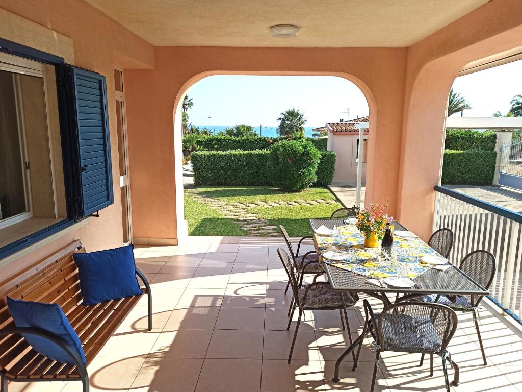 a patio with a table and chairs on a balcony at Tedimo Mare in Marina di Ragusa