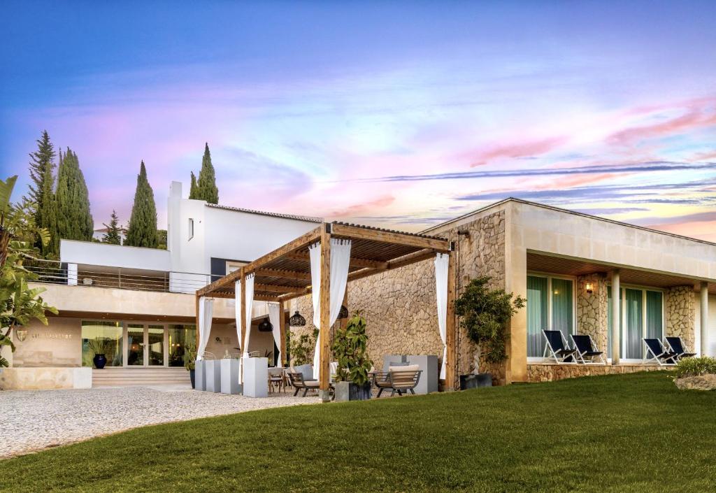 a house with a stone facade with a lawn at Vila Valverde Design Country Hotel in Luz