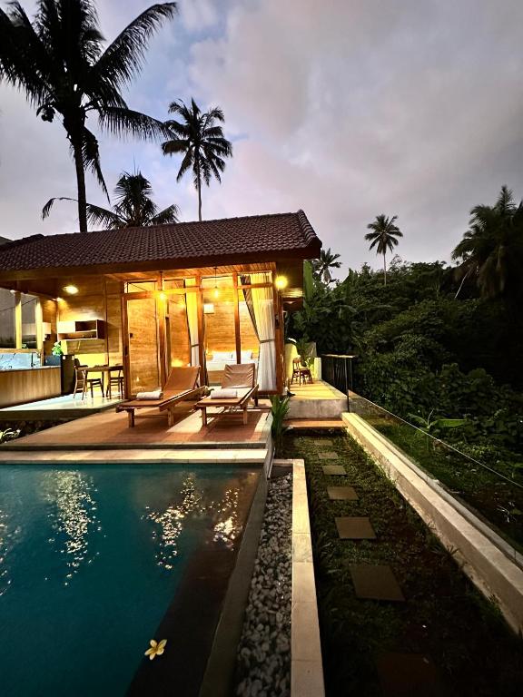 a villa with a swimming pool and a house at Villa Pondok Utu, Ubud - Bali in Ubud