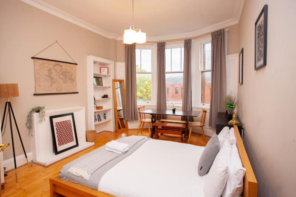 Un dormitorio con una cama y una mesa dentro. en Beautiful 2 Bed Apartment Rose St, en Glasgow