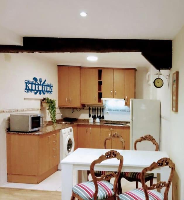 a kitchen with a white table and two chairs at Días de Sur in Santander
