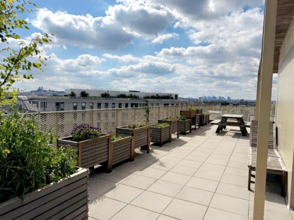 d'une terrasse avec bancs et table de pique-nique sur le toit. dans l'établissement La belle vie, à Saint-Denis