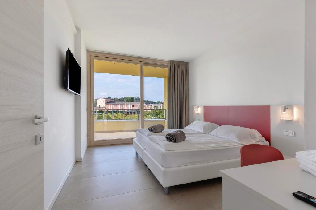Una habitación de hotel con una cama y una ventana grande. en Agriturismo Le Campagnole Red, en Bardolino