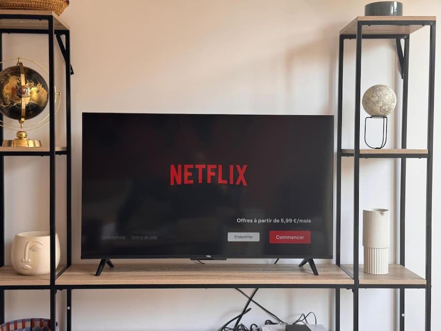a tv on a shelf with a netflix sign on it at Appart premium à 5 min de l aeroport Orly in Athis-Mons