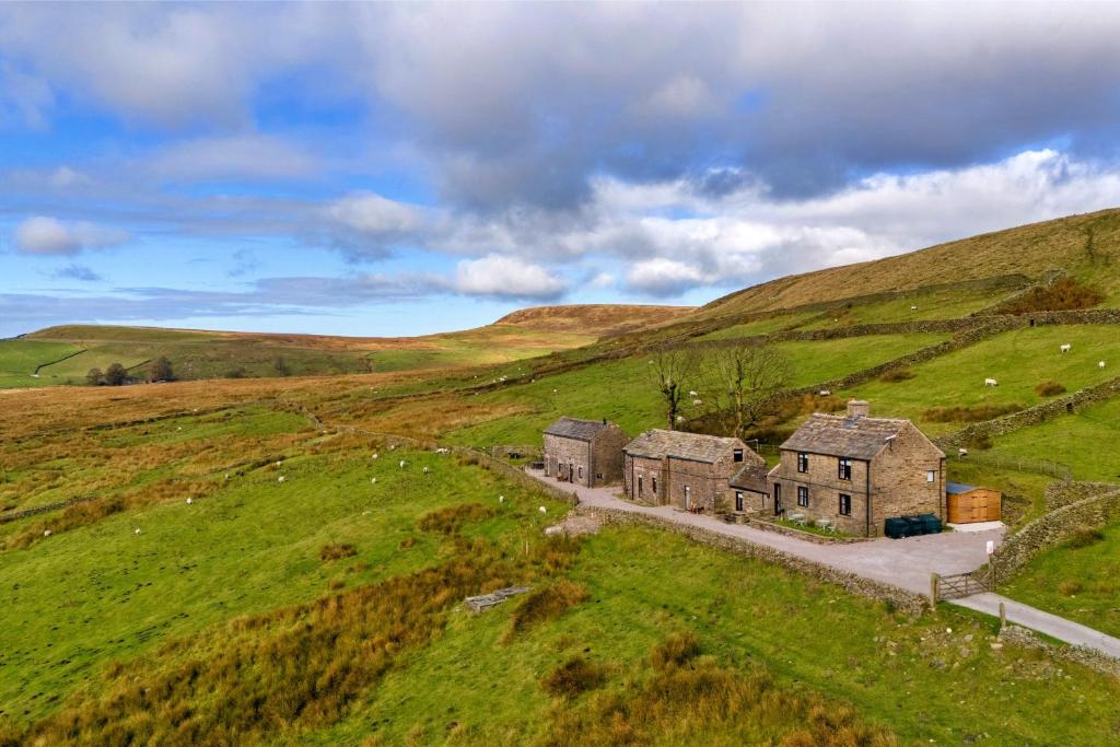an old house in the middle of a green field at Finest Retreats - End Barn at Blackclough Farm in Buxton