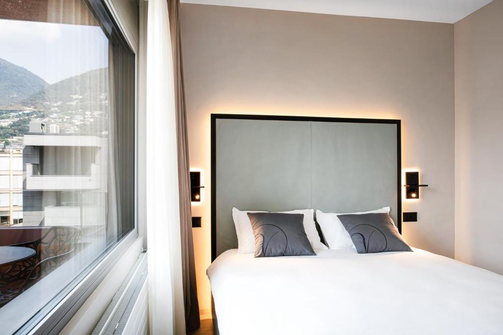 Letto o letti in una camera di VISIONAPARTMENTS Lugano - contactless check-in
