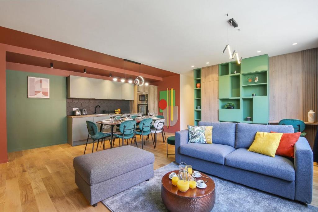 un salon avec un canapé bleu et une cuisine dans l'établissement Bluestay 88 - Superbe appartement à Paris, à Paris