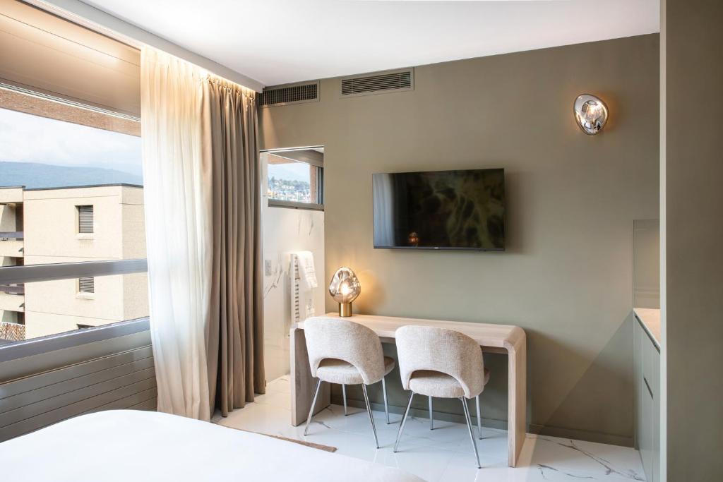 una camera da letto con un tavolo e due sedie e una finestra di VISIONAPARTMENTS Lugano - contactless check-in a Lugano